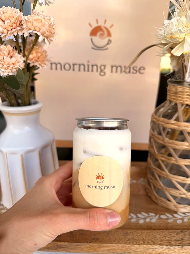 An iced Morning Muse latte held in hand