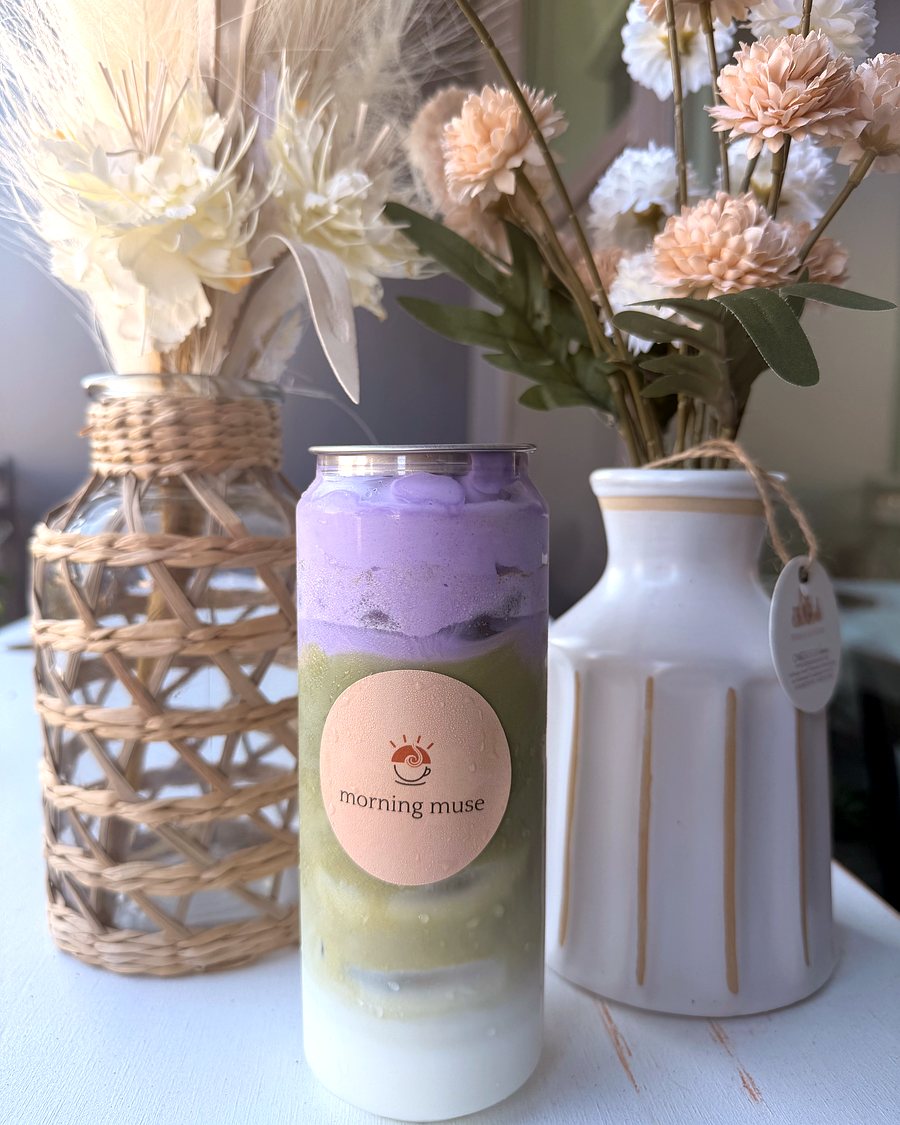Ube Matcha latte in a Morning Muse can, purple ube layered over green matcha, styled with dried flowers