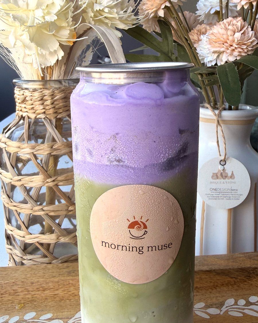 Ube Matcha latte in a Morning Muse can, purple ube layered over green matcha, styled with dried flowers